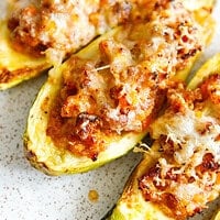 Close-up of stuffed zucchini boats with bubbly melted mozzarella and Parmesan over ground beef filling