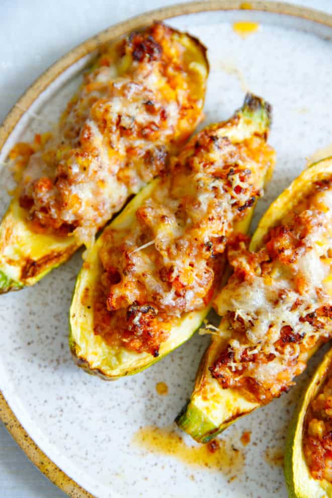 stuffed zucchini boats on a speckled plate