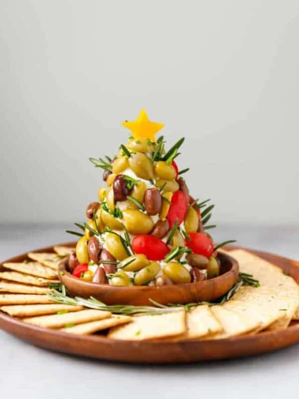 A Christmas Tree shaped cheese ball on a wooden platter