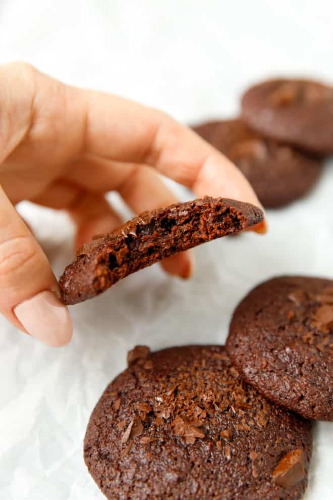 a hand holding vegan almond flour chocolate cookie