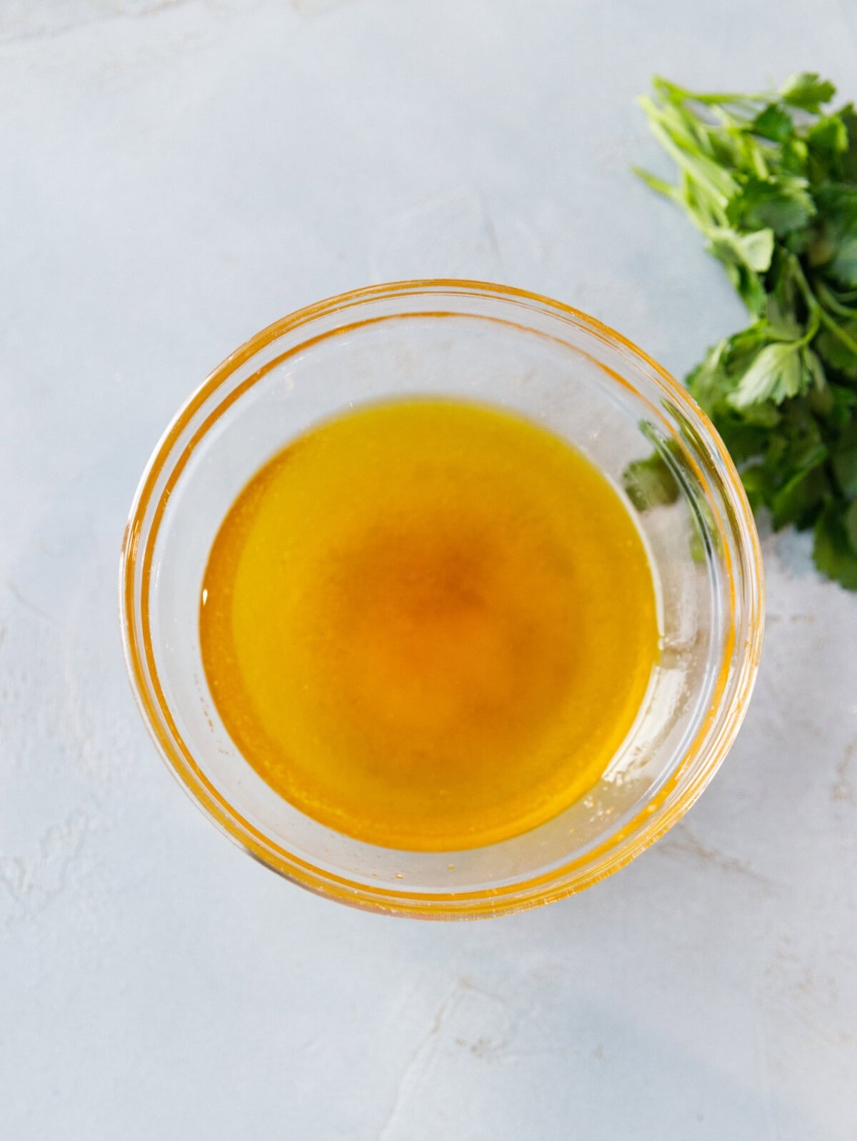 Olive oil and apple cider vinegar dressing for purple cabbage salad in a glass bowl