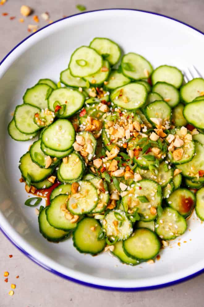 Cucumber salad in a white bowl with blue rims