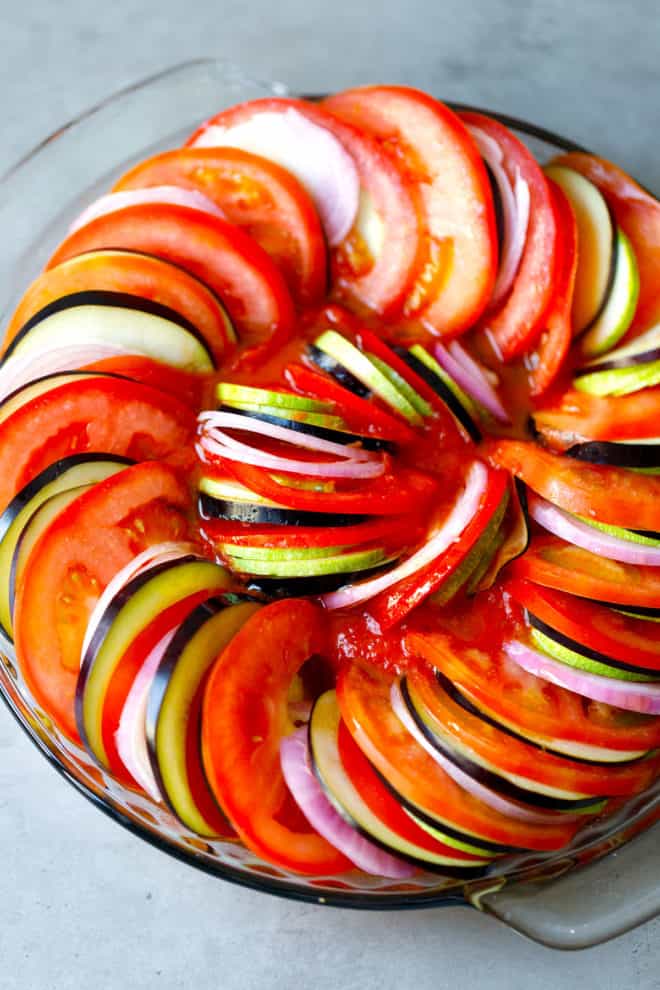 Layered vegetables for ratatouille in a baking dish