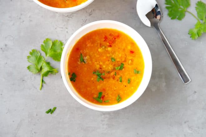 A white bowl with red lentil soup