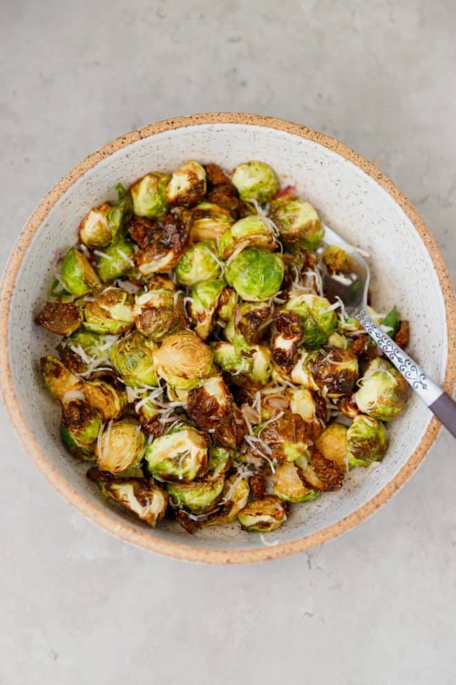 A bowl with Air Fryer Brussels sprouts topped with Parmesan