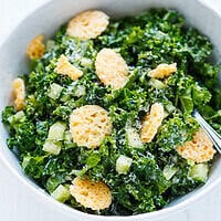 Close-up of kale Caesar salad with crispy Parmesan crisps, cucumber and grated Parmesan