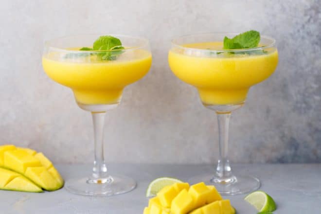 Two glasses filled with mango daiquiri