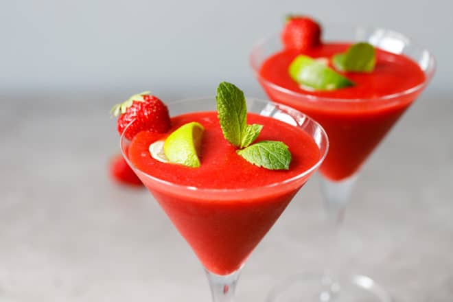 Two martini glasses with strawberry daiquiri cocktail inside