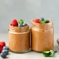 Two jars with vegan chocolate mousse topped with berries