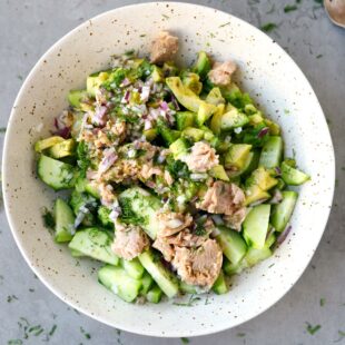 Avocado tuna cucumber salad in a speckled bowl