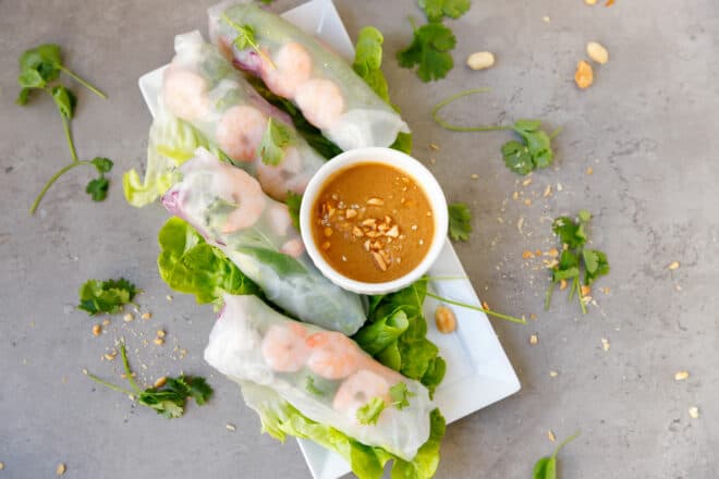 A platter with shrimp rolls with peanut dipping sauce