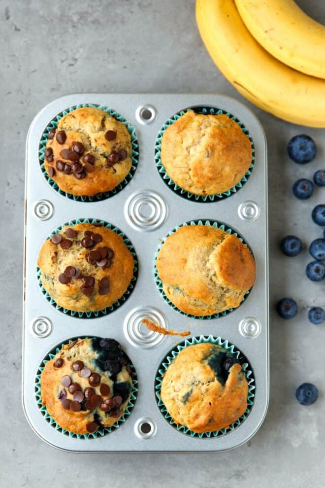 Gluten-free blueberry banana chocolate chip muffins in a muffin tin.