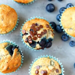 Gluten-free banana muffins in blue paper liners on a gray surface