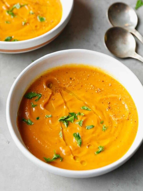 Bowl with carrot soup and lime wedges