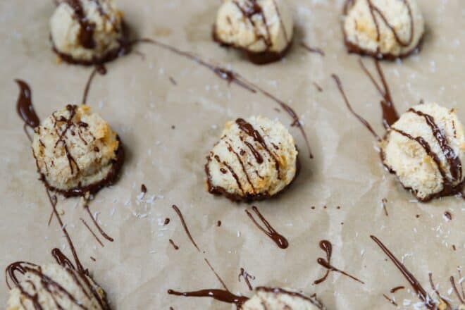 Coconut macaroons on parchment paper, drizzled with chocolate