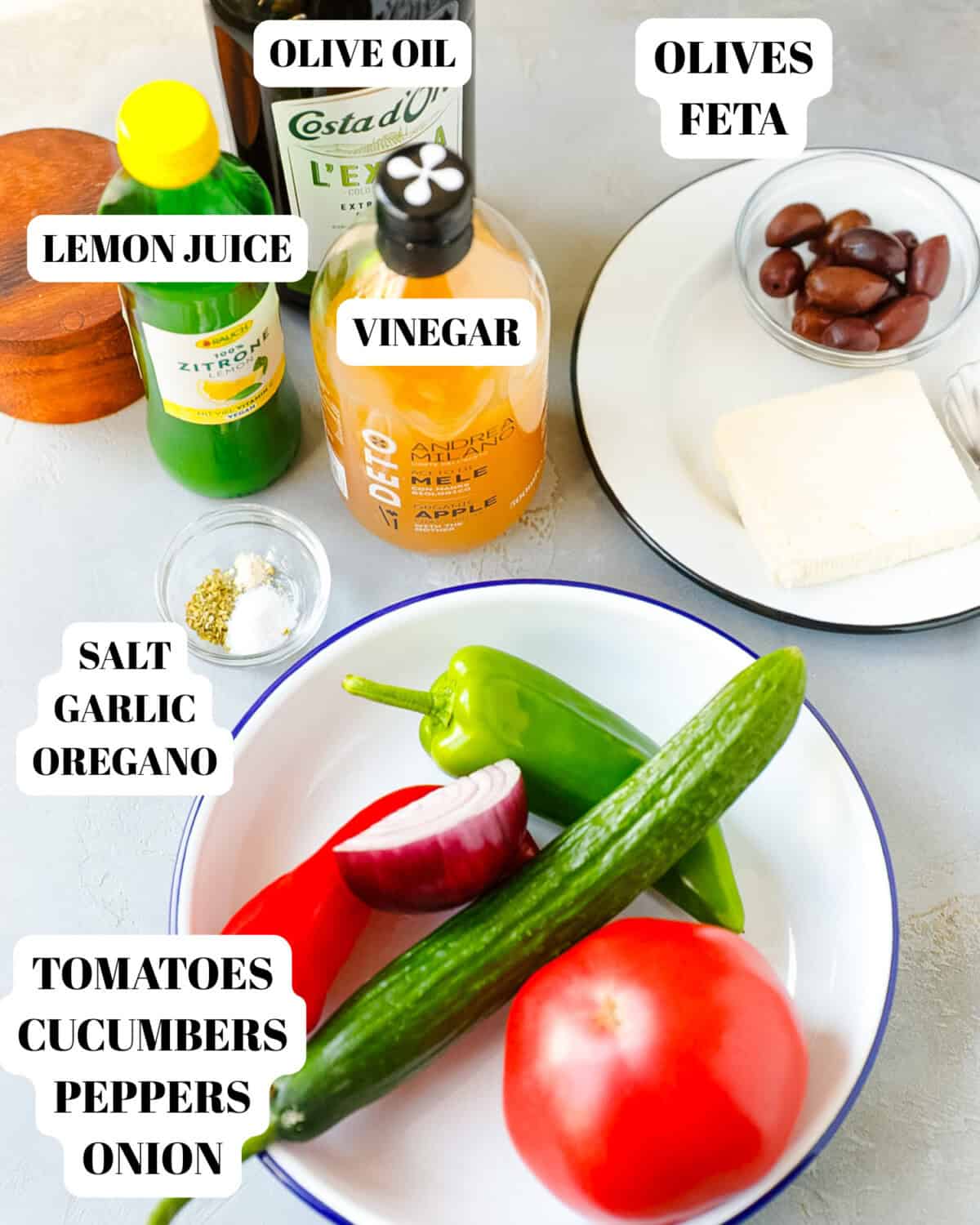 Greek salad ingredients with cucumber, tomato, feta cheese, olives, bell peppers, onion and olive oil for Mediterranean salad