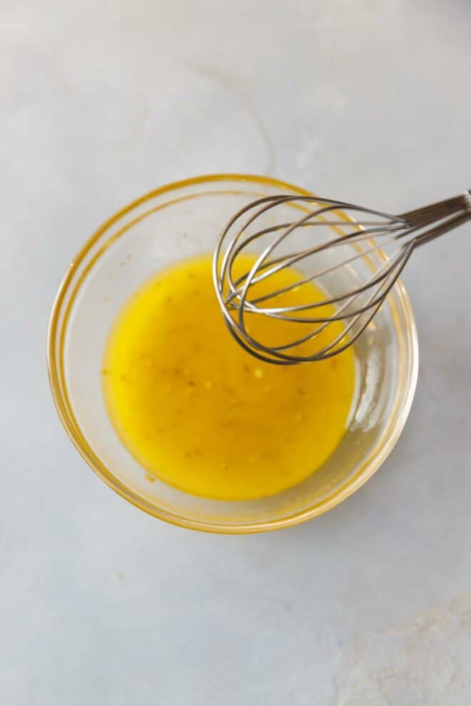 Greek salad dressing (Vinaigrette) in a bowl with a whisk