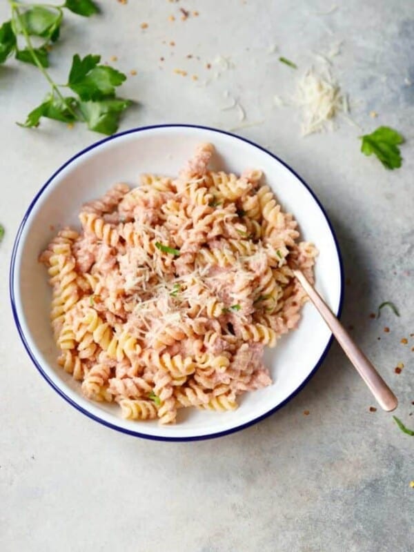 Vegan pink pasta in a white bowl with fork