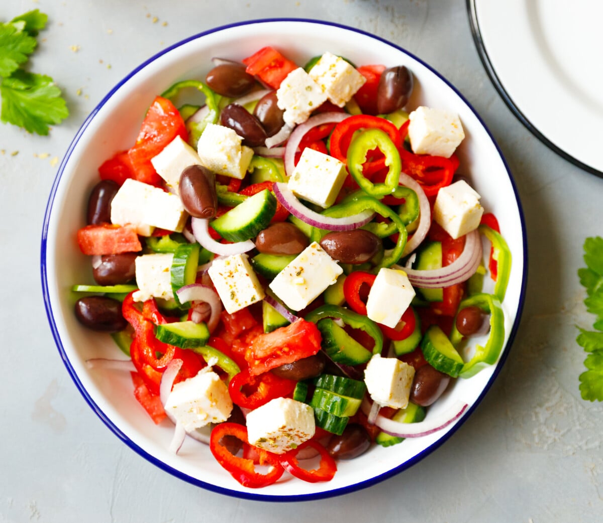 Large bowl Greek salad with feta cheese olives cucumber tomato peppers and onion