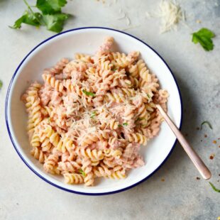 Vegan pink pasta in a white bowl with fork