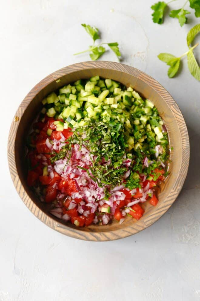 A bowl with chopped vegetables for tomato cucumber Shirazi salad