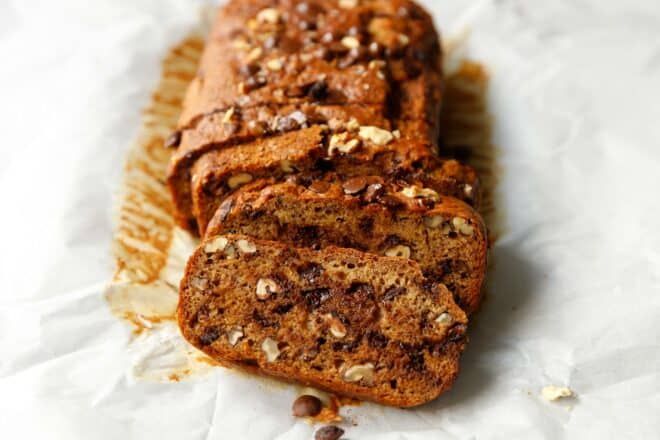 Sliced vegan banana bread on white parchment paper