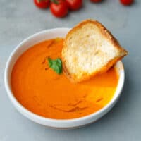 A white bowl with creamy roasted tomato soup