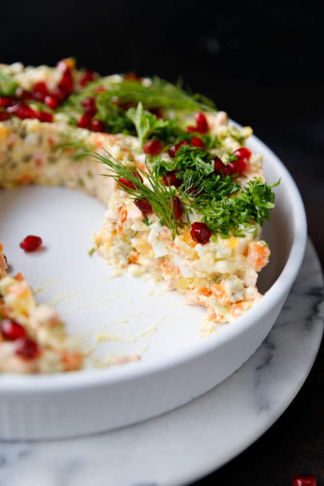 Cut Olivier salad wreath on a white plate