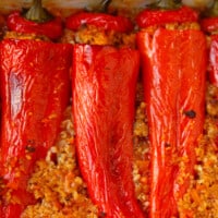 A baking dish with bulgur sttuffed red peppers