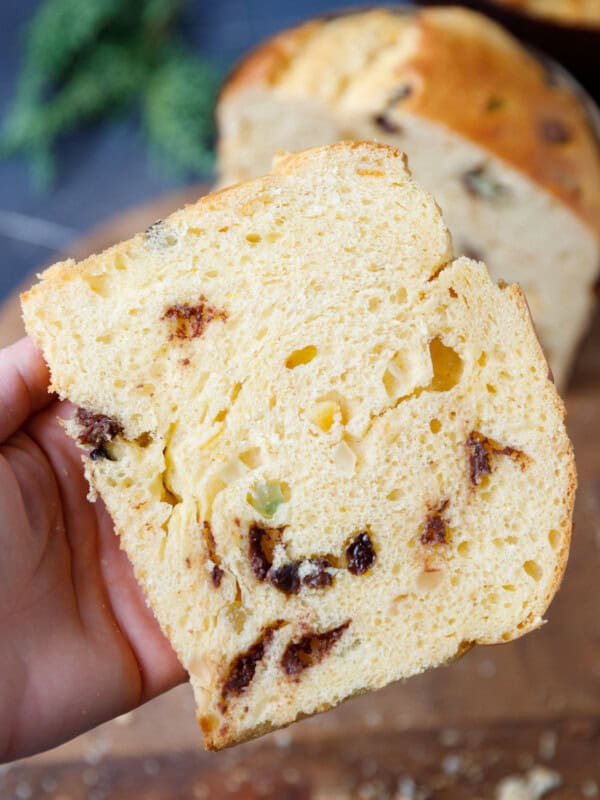 A hand holding Italian Christmas Bread Panettone with raisins