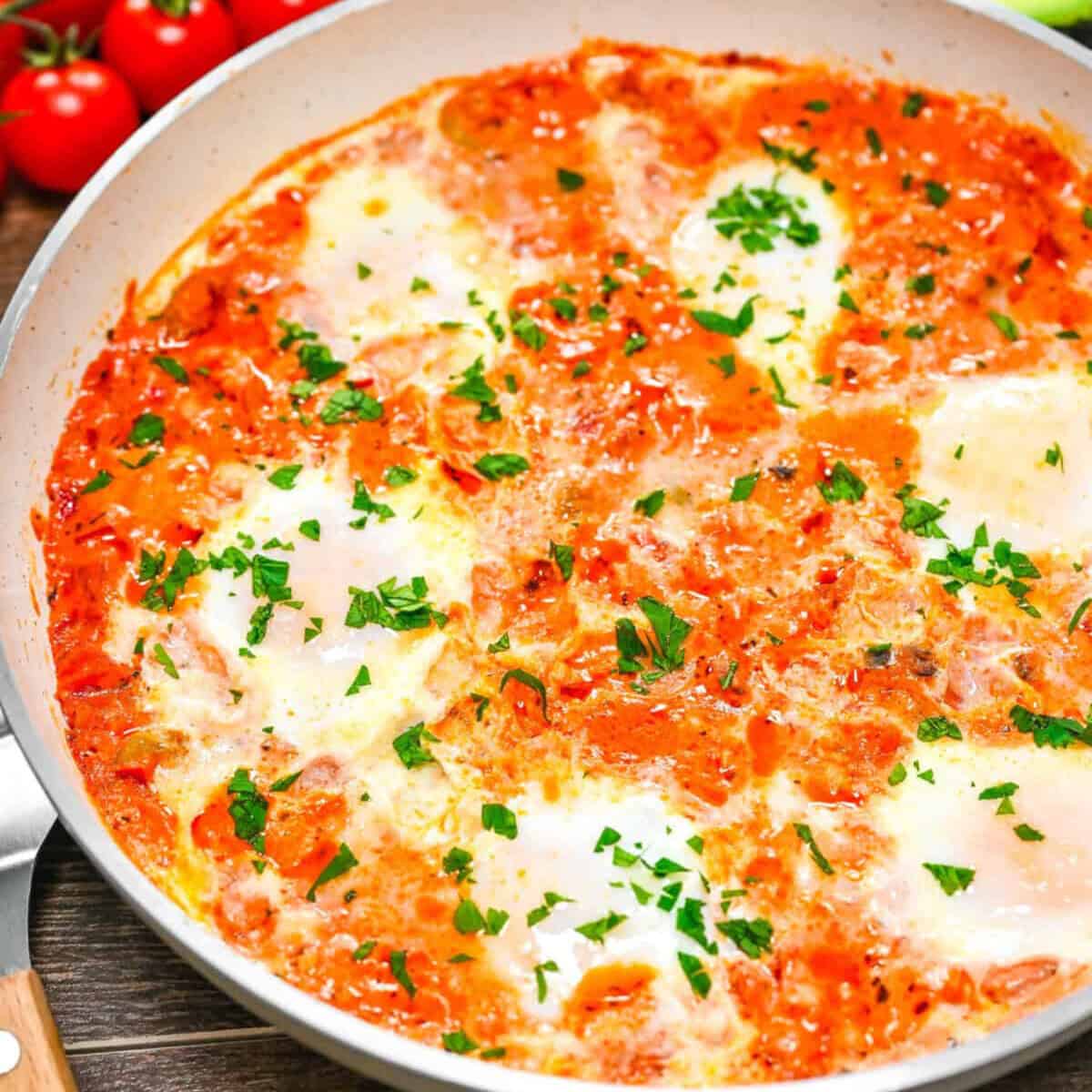 Italian shakshuka in a skillet topped with herbs