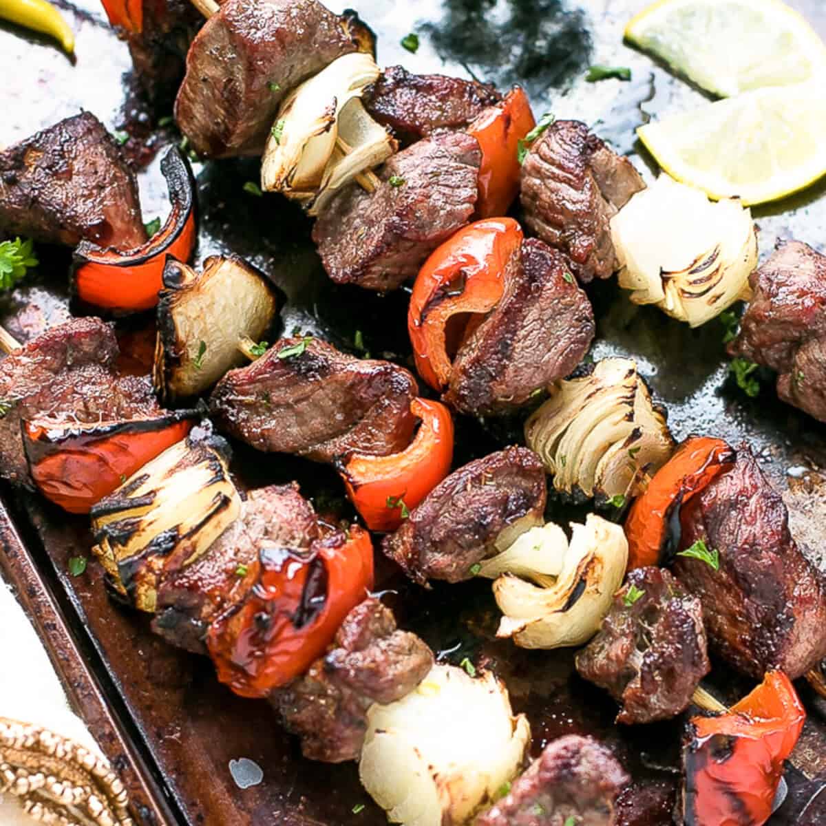 Lamb kebabs with red peppers and onions on a baking dish