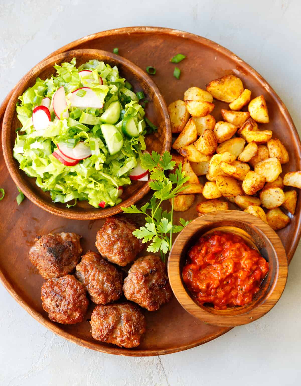 Crispy pan-fried Bulgarian beef meatballs served with fresh parsley and cucumber radish salad.