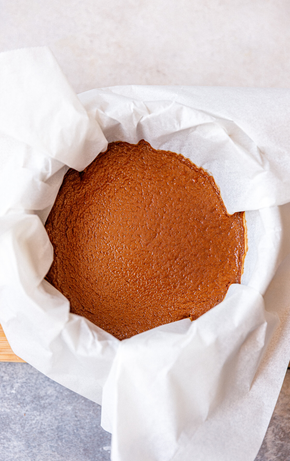 A baked cottage cheese chocolate cheesecake in a round cake pan