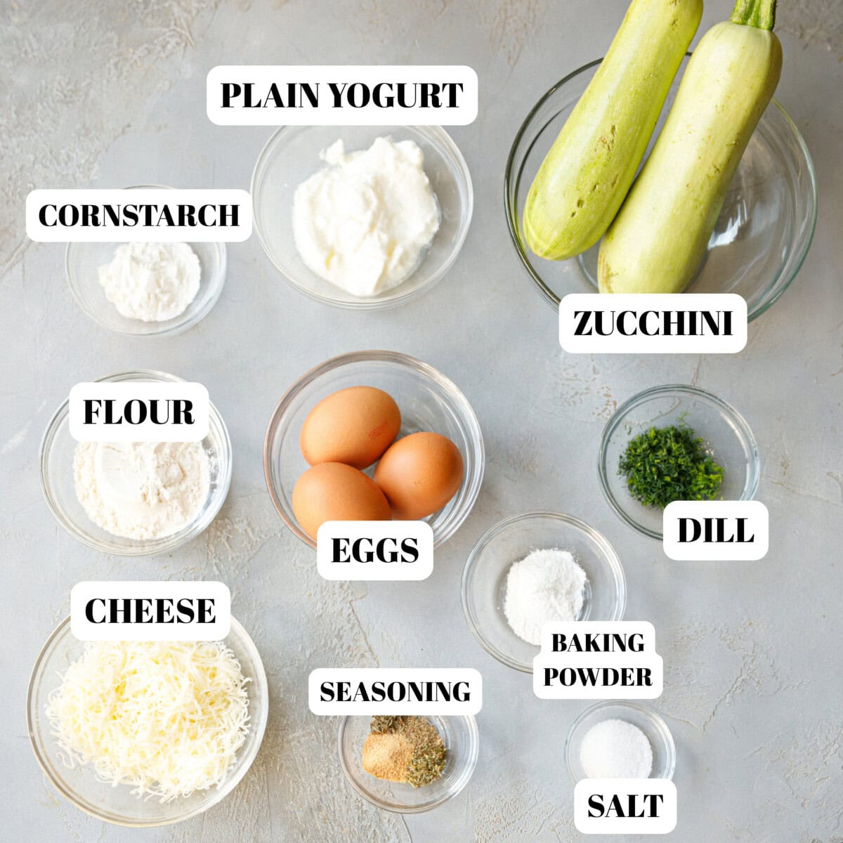 Clear glass bowls with zucchini frittata ingredients