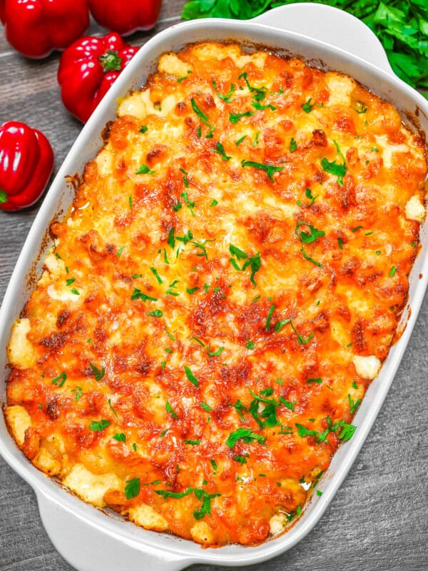 Overhead view of a full pan of baked mac and cheese, bubbly golden top sprinkled with parsley.