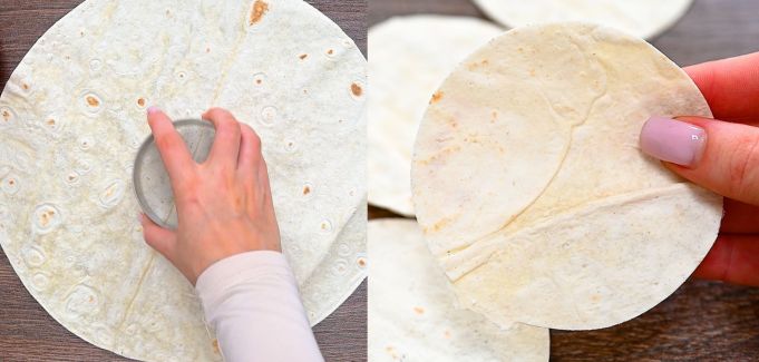 Hand cutting small circles out of tortillas with a glass.