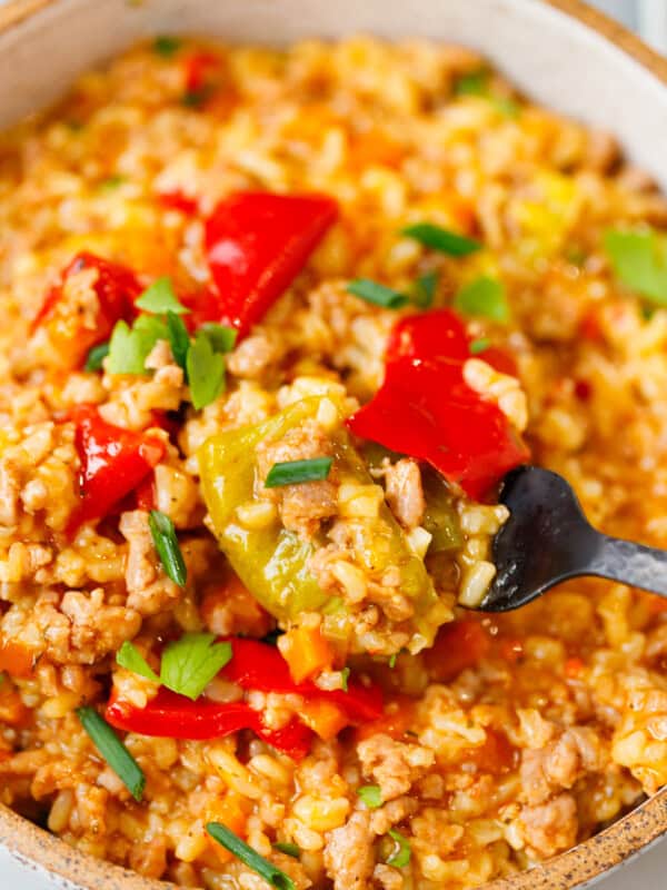 Close-up of a bite of unstuffed peppers with rice, ground beef, and bell peppers on a fork.