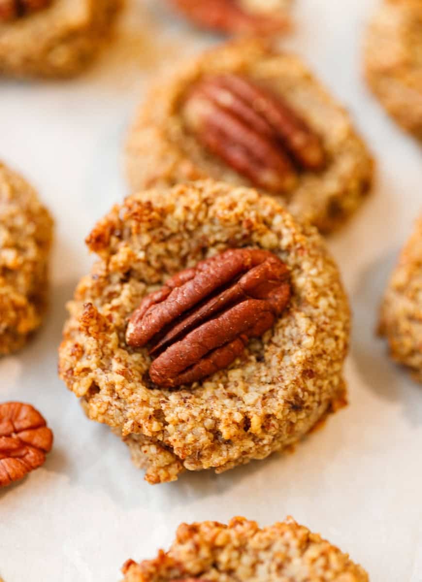 Close up of a maple pecan cookie with a whole pecan pressed into the center.