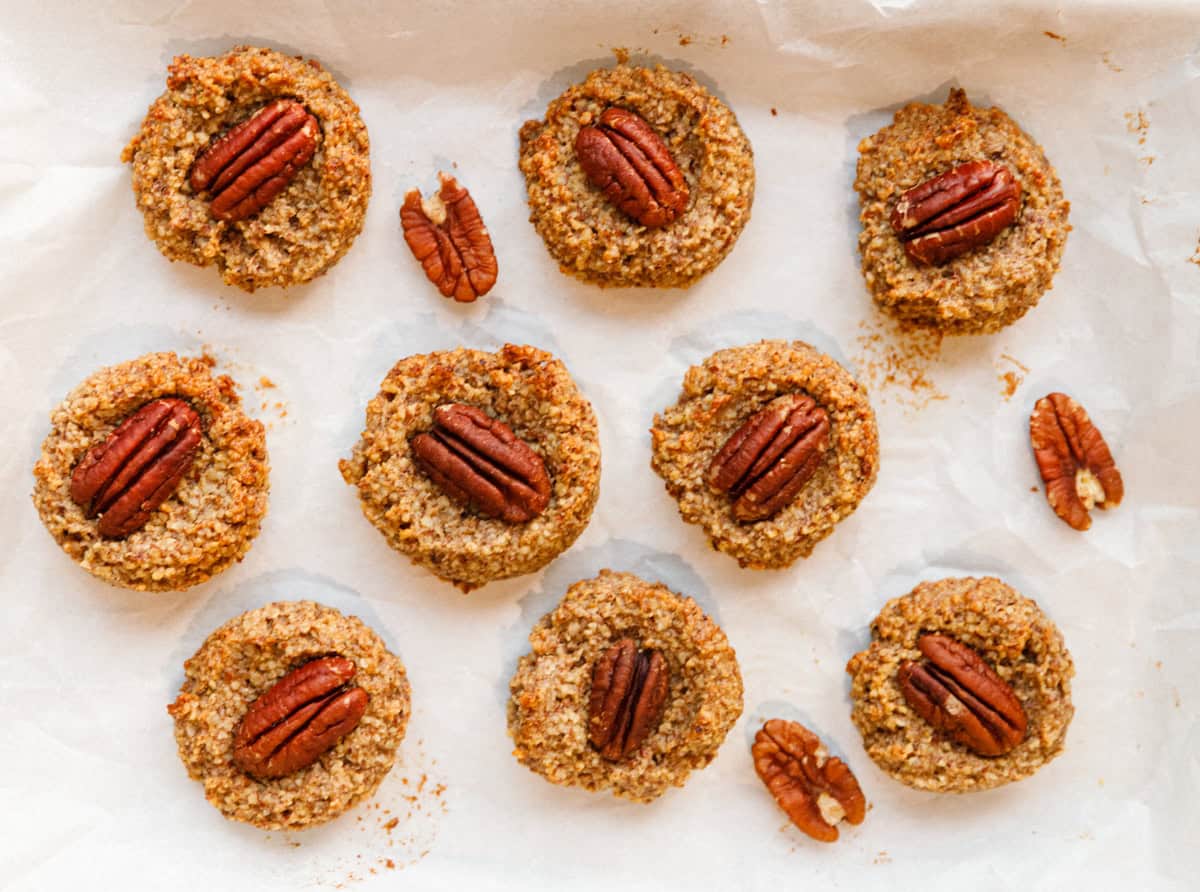 Overhead view of freshly baked maple pecan cookies on a parchment lined baking sheet