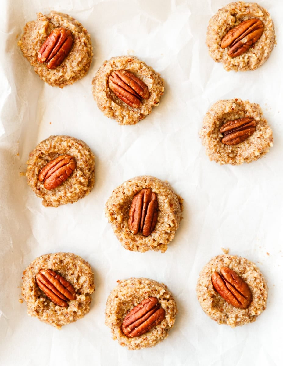 Unbaked maple pecan cookies arranged neatly on a parchment lined baking sheet