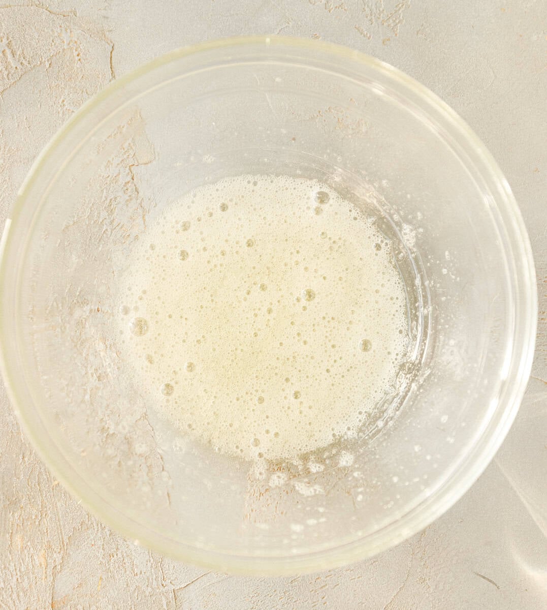 Foamy whisked egg white in a mixing bowl before adding maple syrup