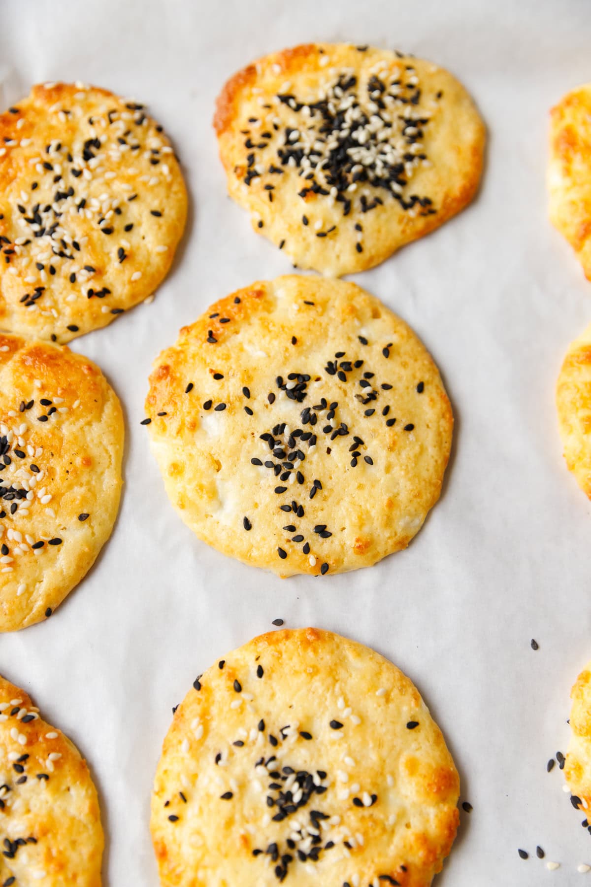 Golden low-carb cottage cheese flatbreads with sesame seeds on baking paper