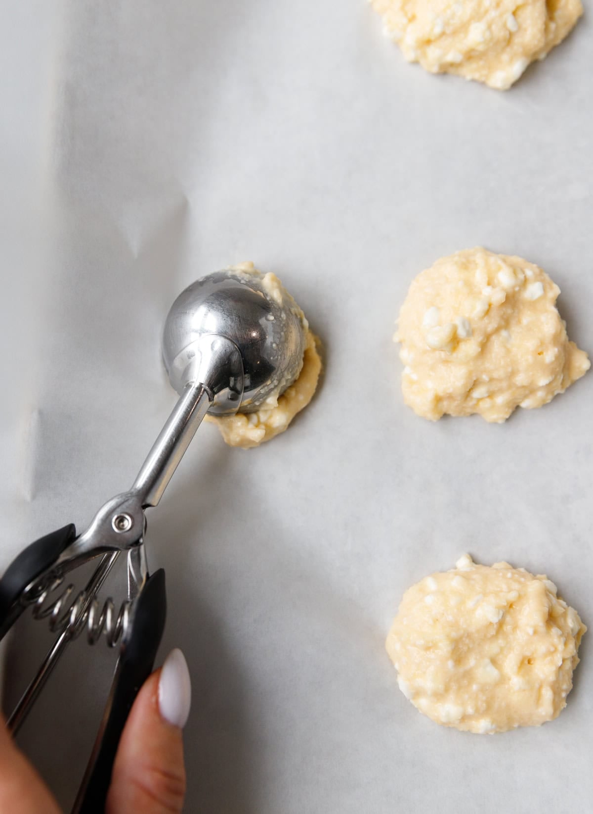 Shaping low-carb cottage cheese flatbread batter into rounds on parchment