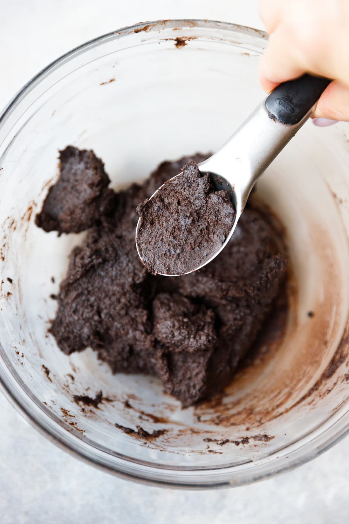 Oreo truffle mixture scooped from a bowl with a spoon