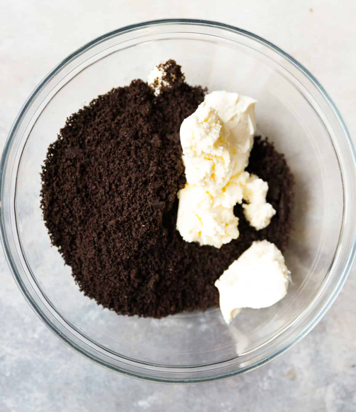Crushed Oreos and cream cheese in a bowl before mixing