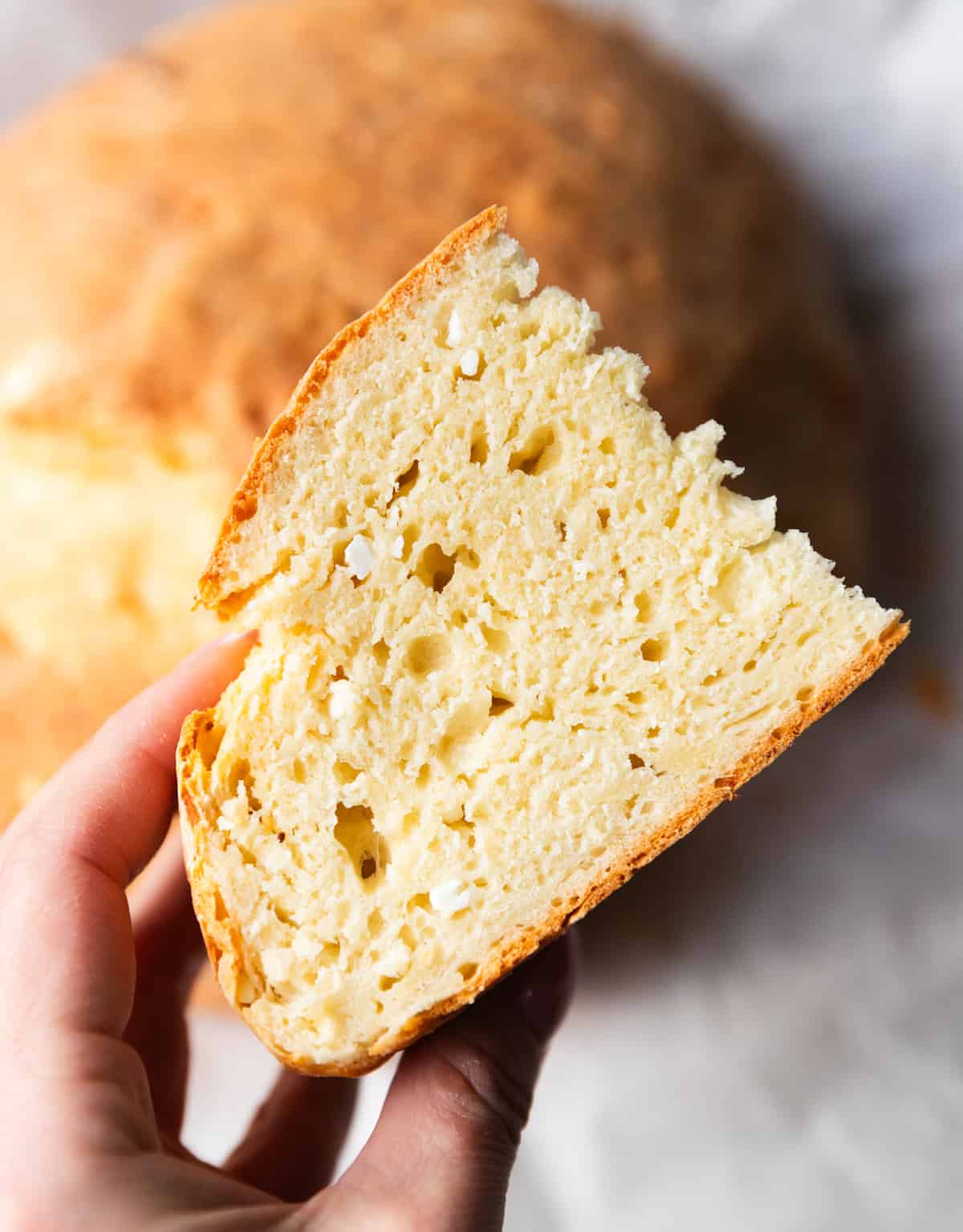 Hand holding a slice of yogurt feta bread