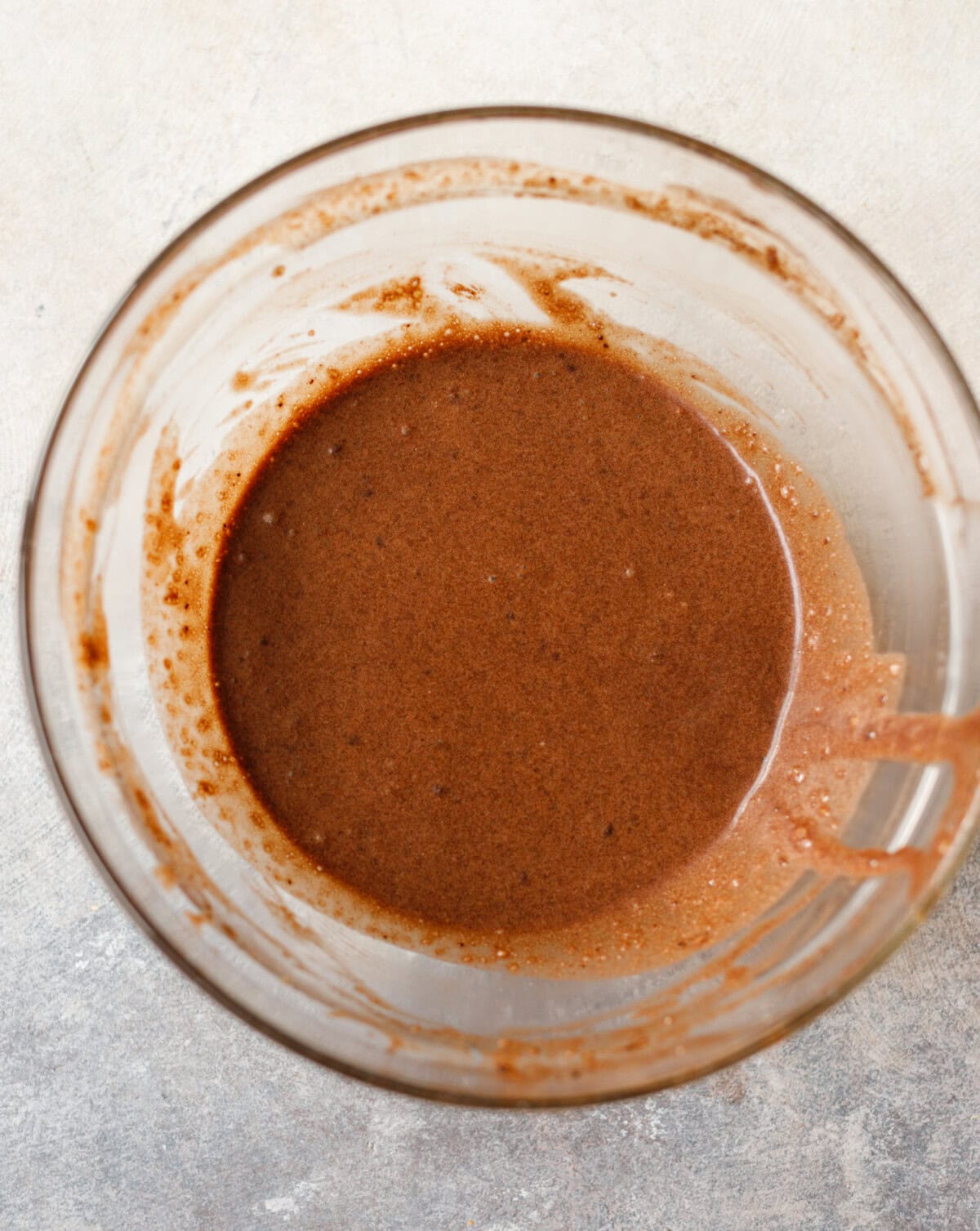 Smooth chocolate collagen cake batter in a glass bowl ready for baking