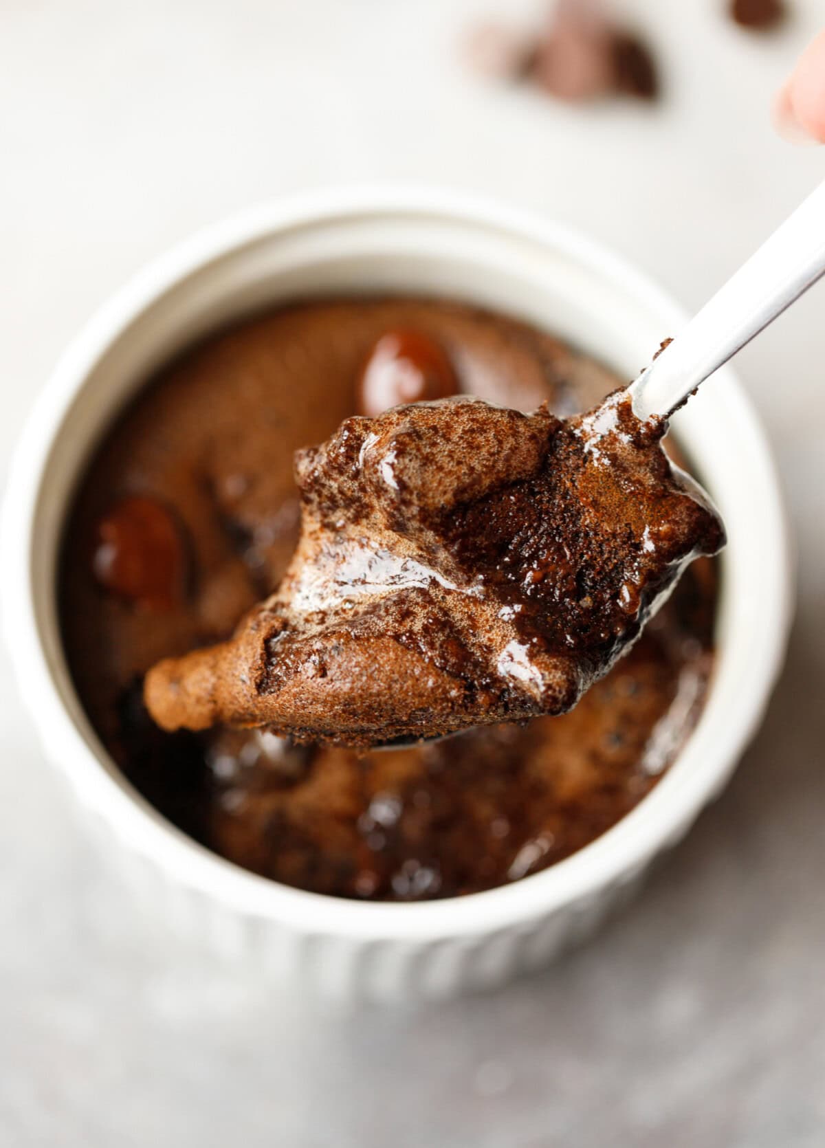 Close-up of gooey chocolate collagen mug cake on a spoon showing soft texture