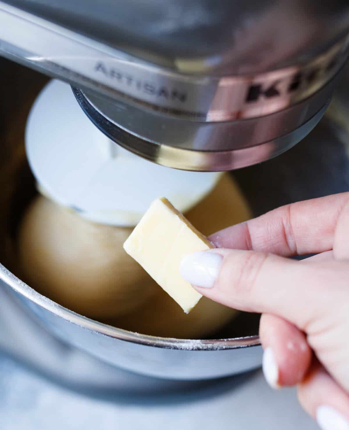 adding softened butter gradually to kulich dough during kneading